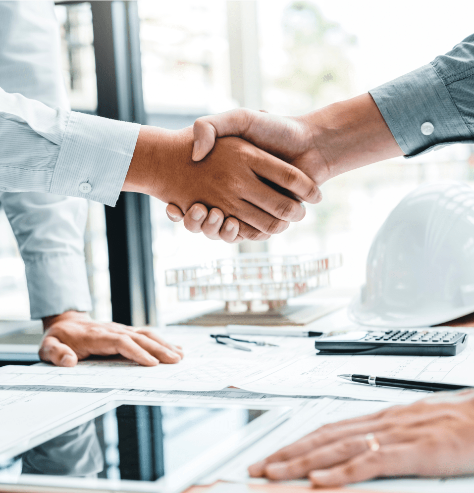 Two people shaking hands across a desk