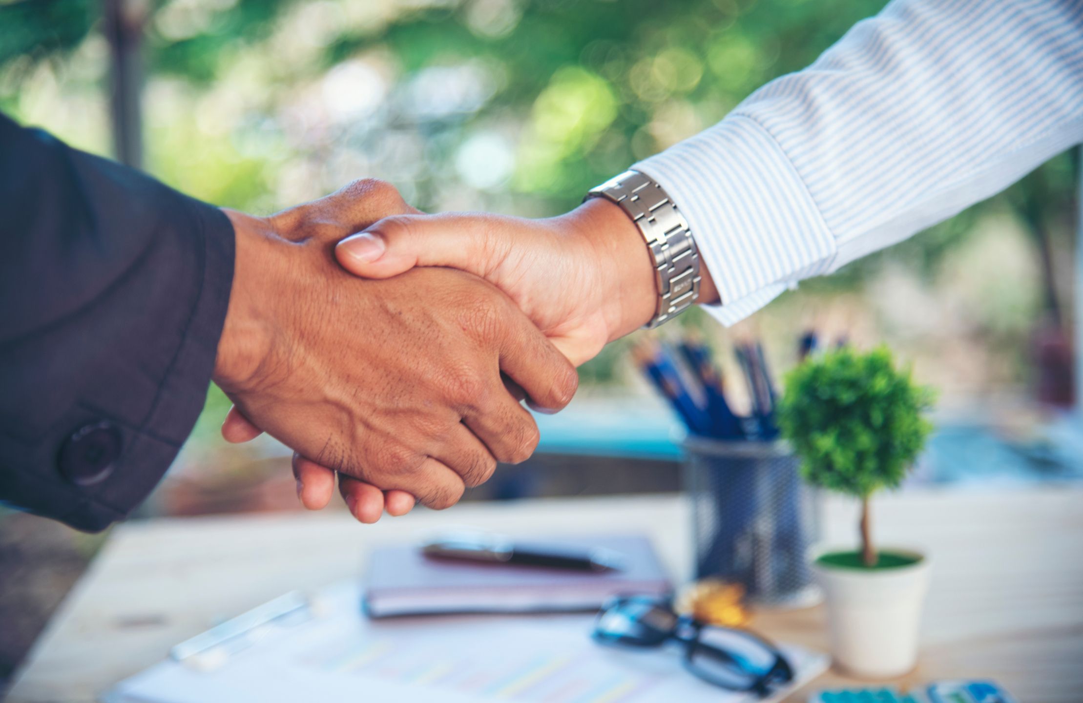 Two men shaking hands over a desk